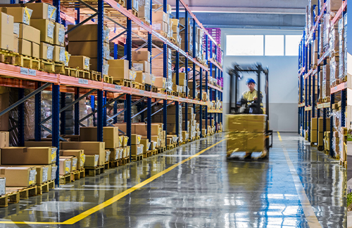 warehouse-floor Worker driving lift on warehouse floor